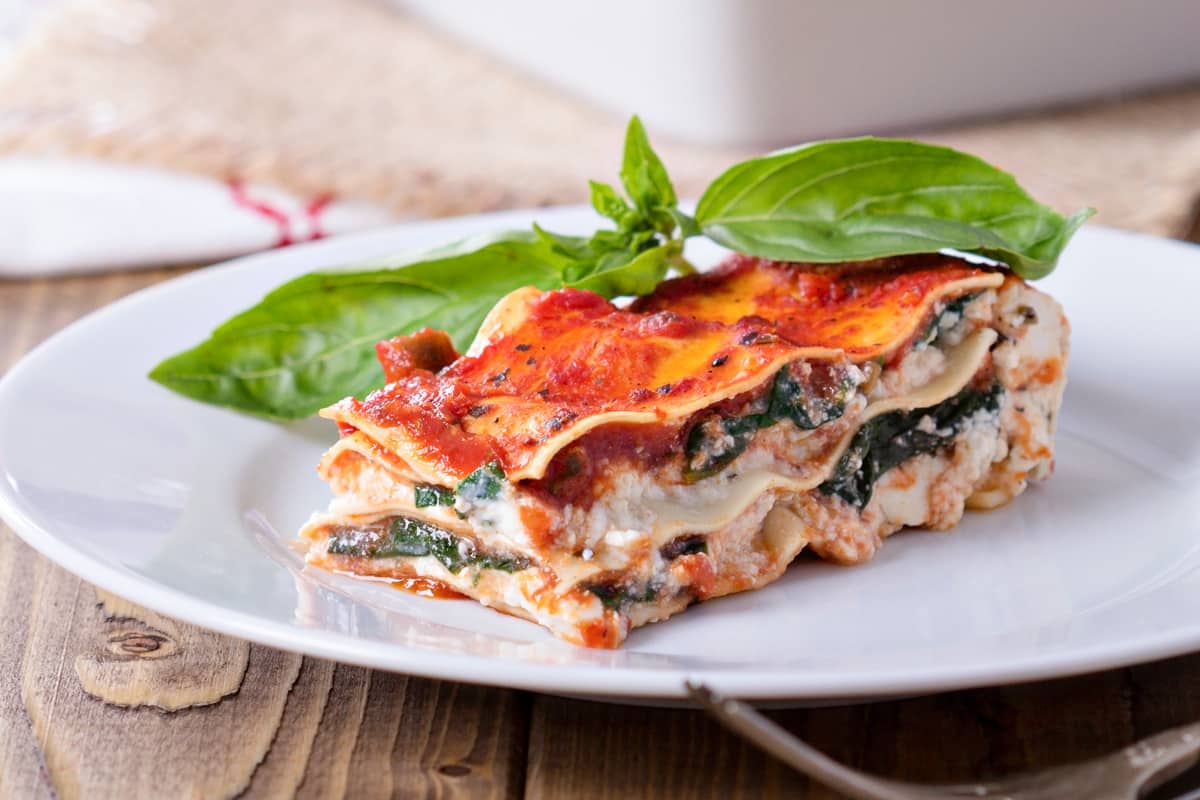 close up slice of best vegan lasagna on white plate