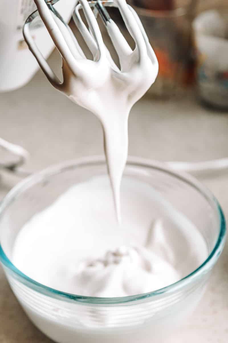 beater pulling up out of bowl full of vegan whipped coconut cream