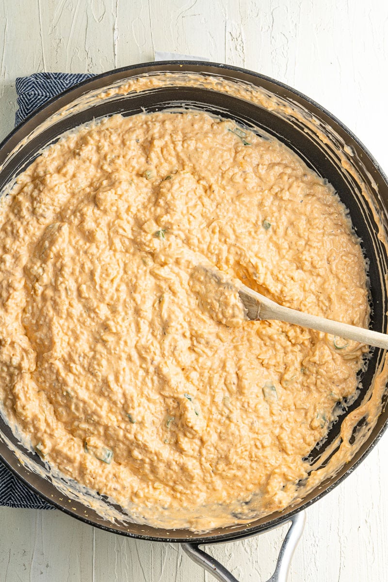 large skillet filled with buffalo cauliflower dip