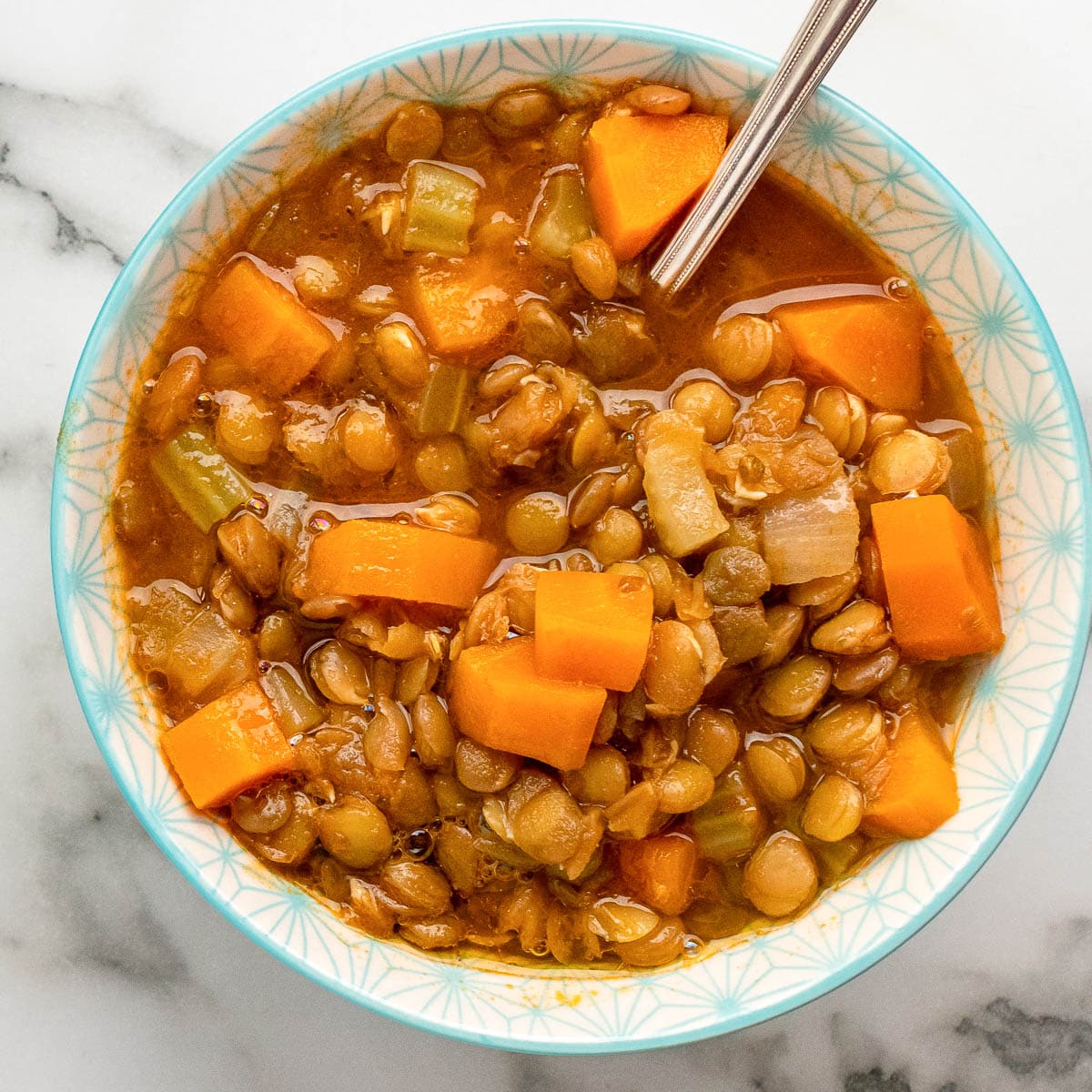 top view blue and white bowl of greek lentil soup