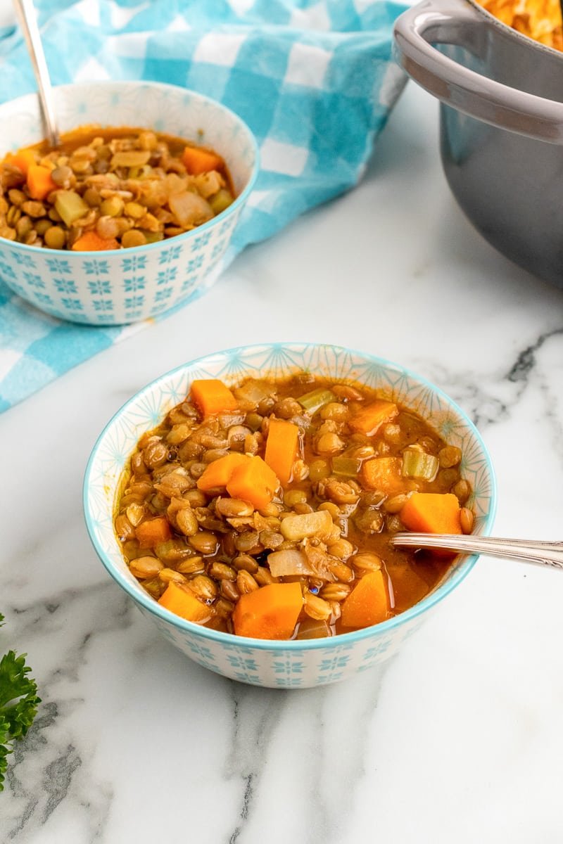 two small bowls of greek lentil soup with spoons