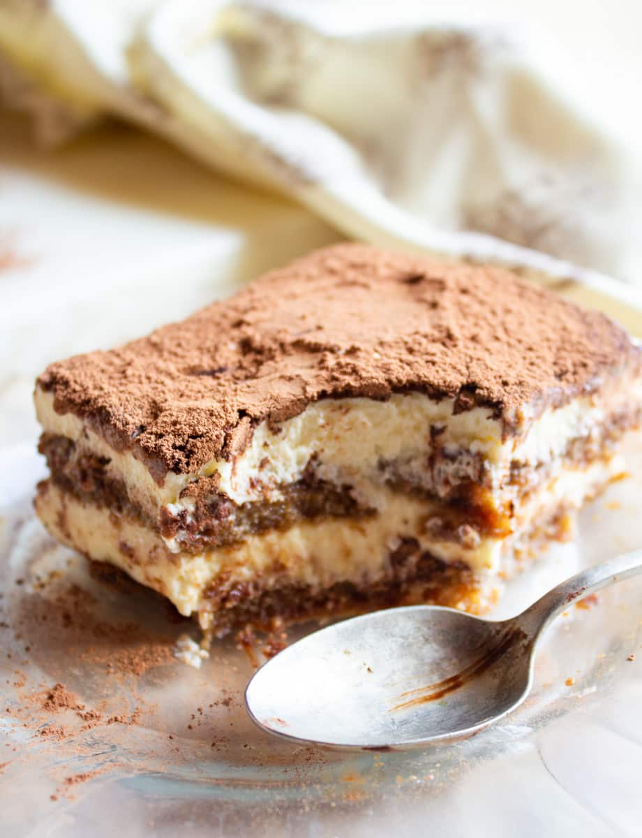 slice of best homemade tiramisu with bite taken out next to metal spoon