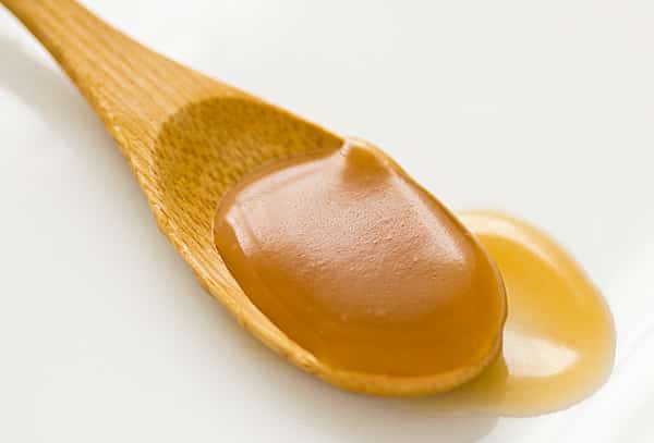 wooden spoon filled with vegan caramel sauce