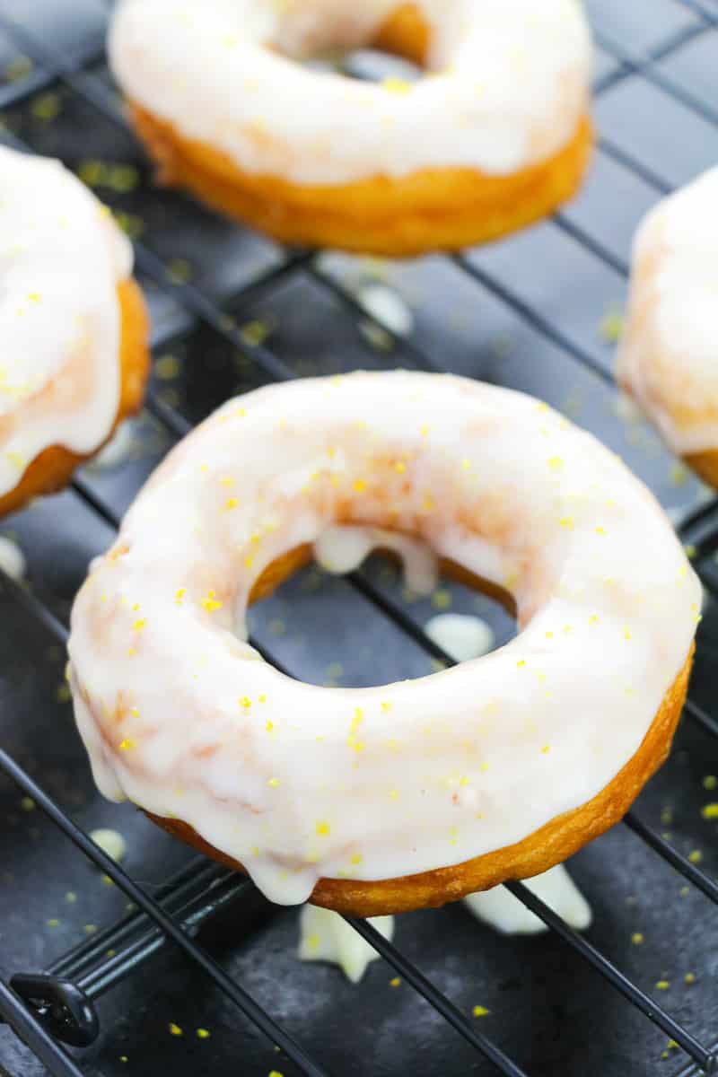 glazed lemon donuts dripping on cooling rack