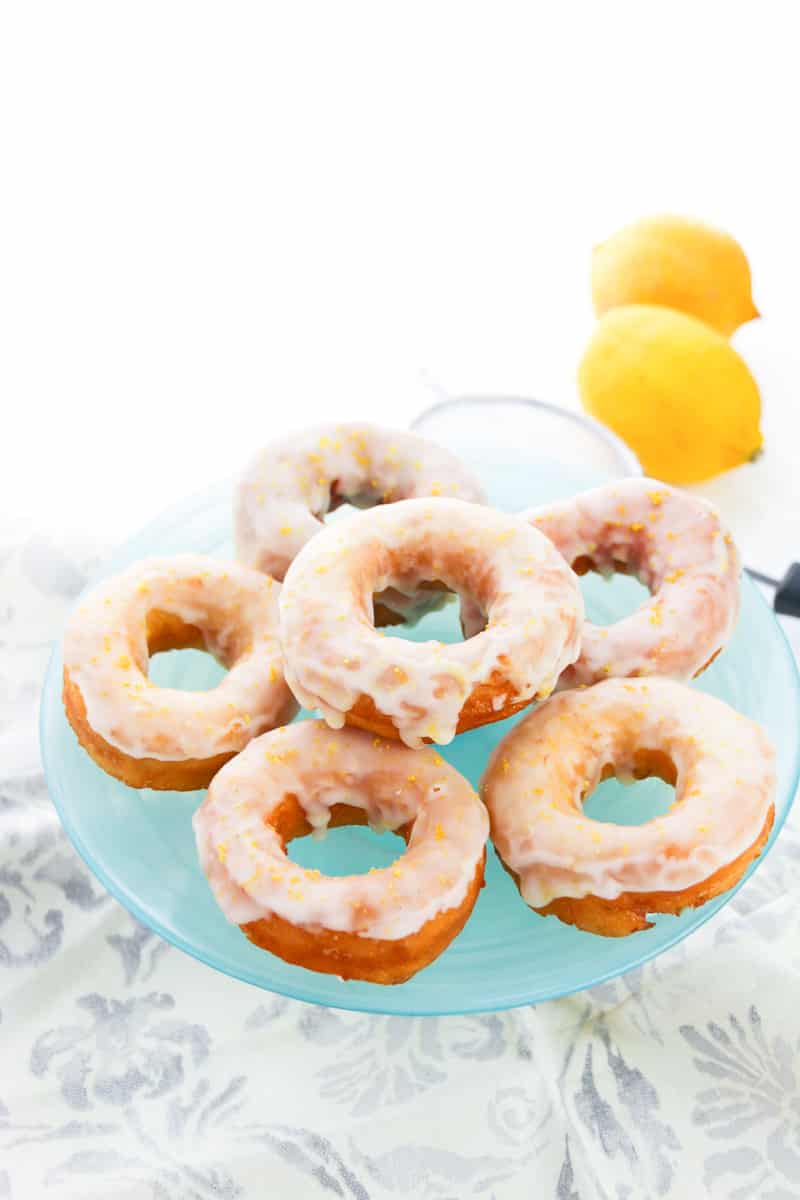 far out view of glazed lemon donuts stacked on blue plate