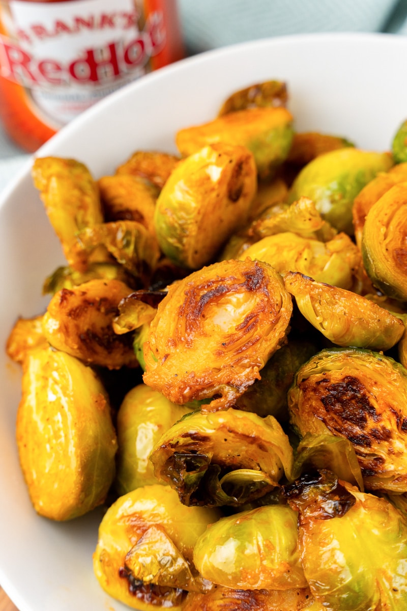 buffalo brussels sprouts being served in a white bowl