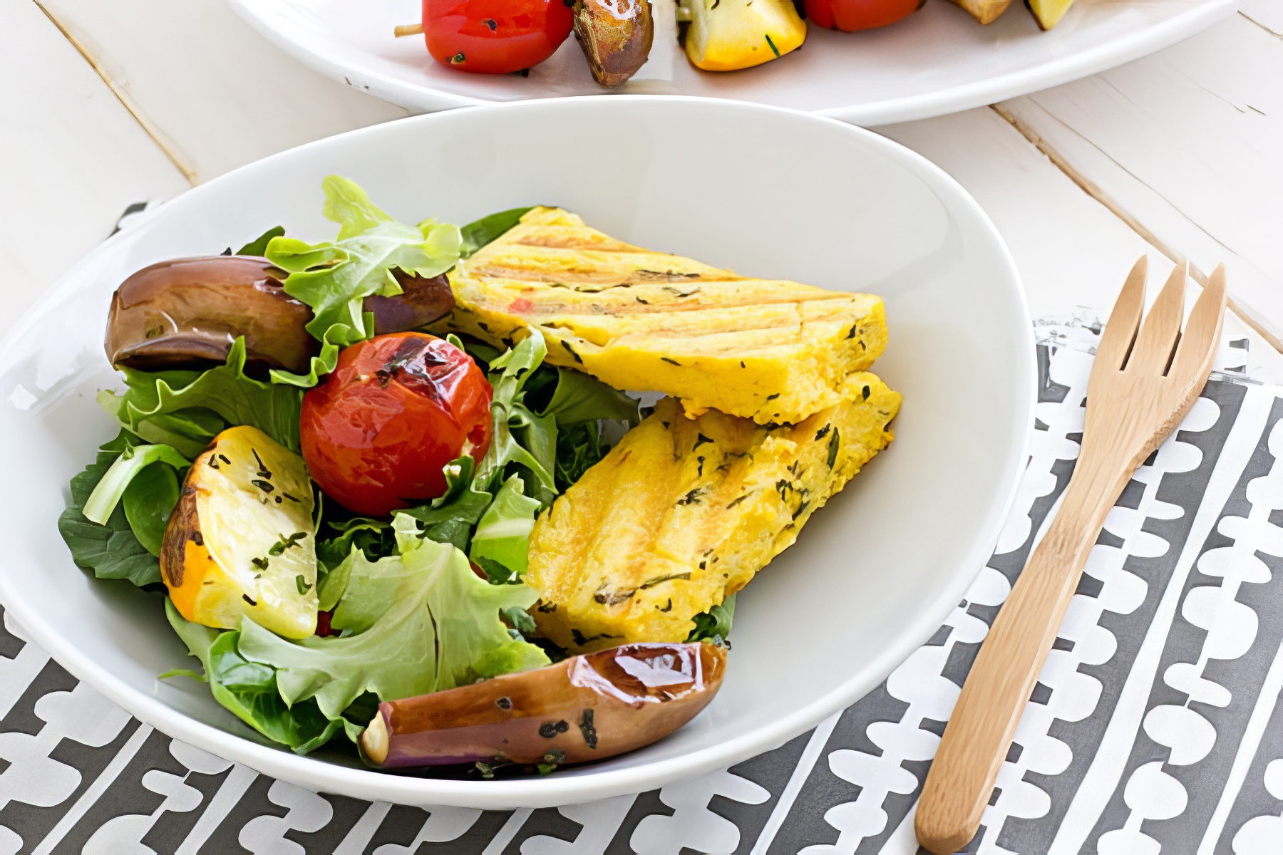 grilled polenta on top of a grilled veggie salad