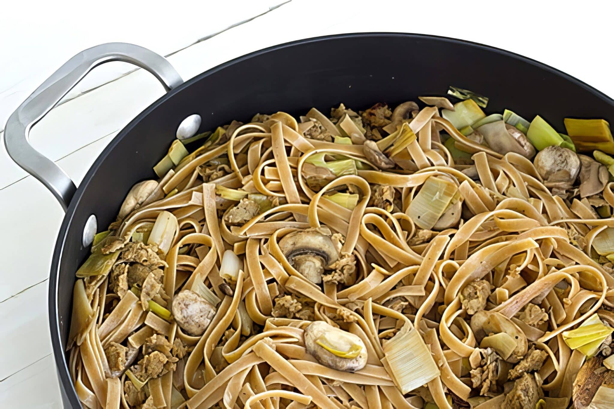 wild mushroom fettucine with vegan sausage in a large pan