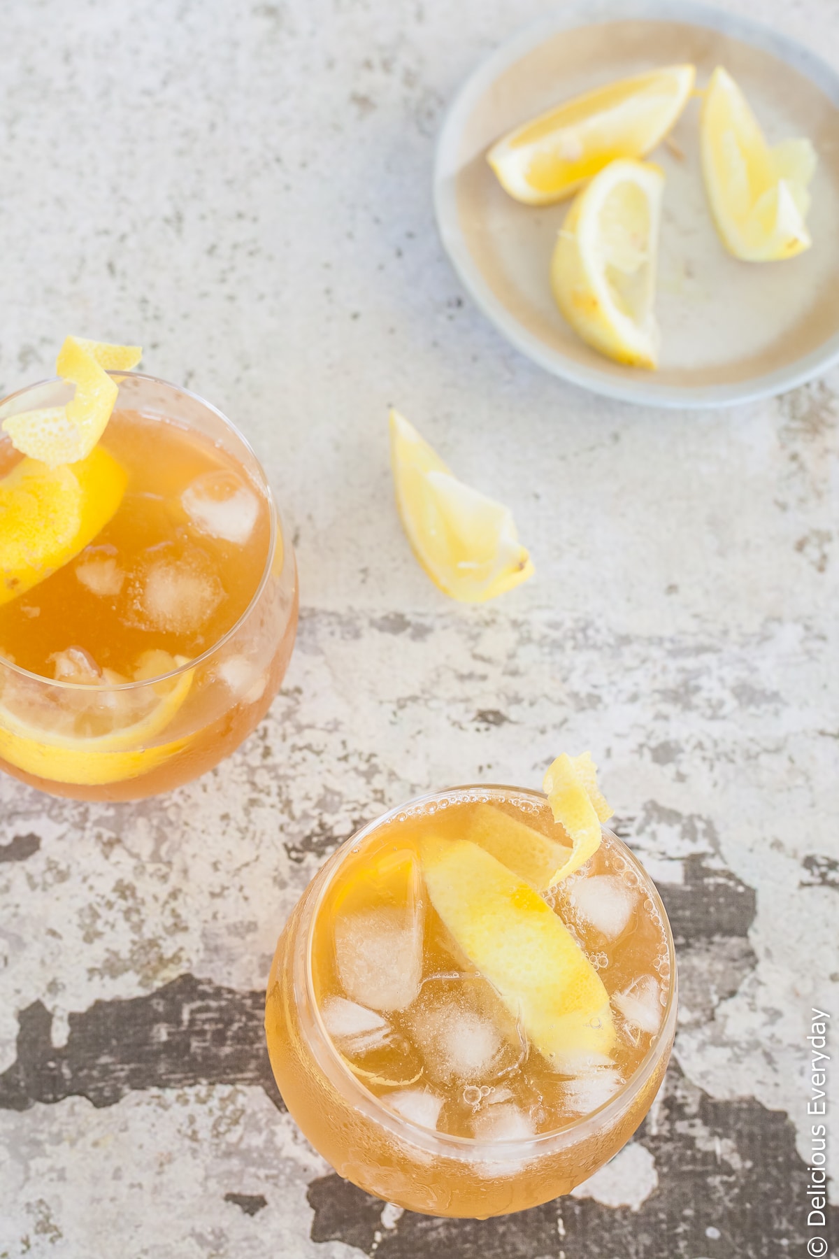 an amaretto sour cocktail being served with a lemon peel