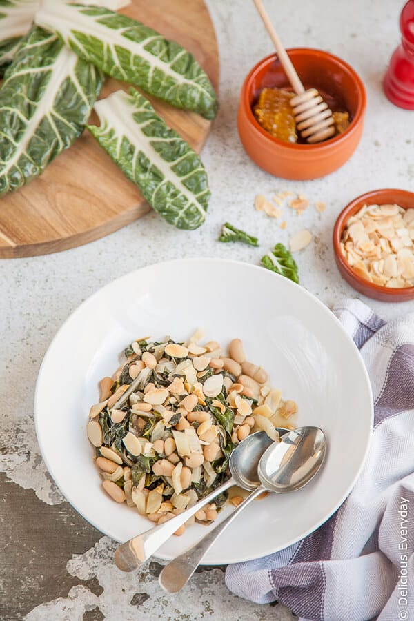 Quick, easy and delicious! This super side pairs slightly bitter chard with sweet honey, cannelloni beans and toasted almonds comes together in under 15 minutes. | Get this and more vegetarian recipes at DeliciousEveryday.com