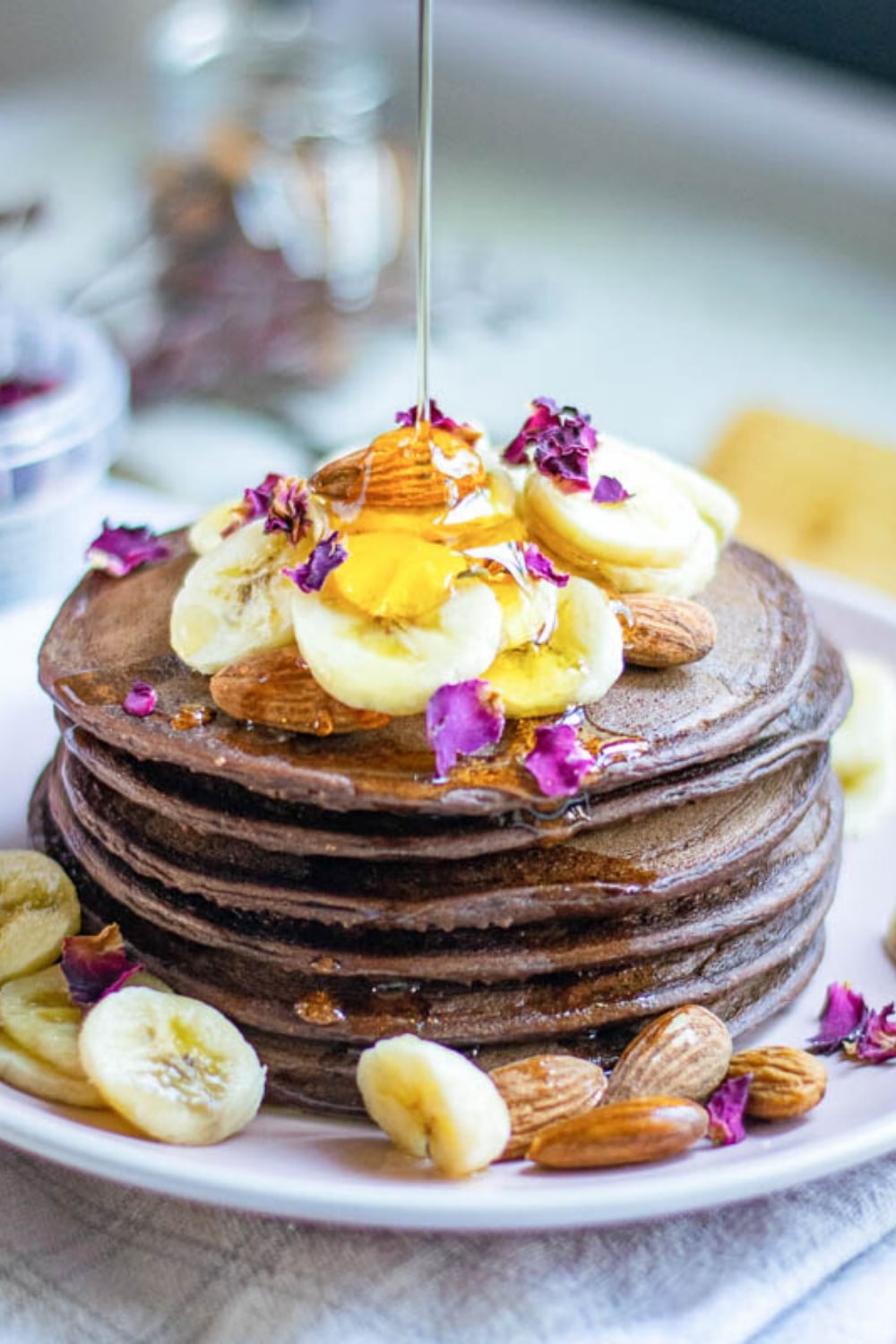 close up of vegan pancakes with syrup pouring over