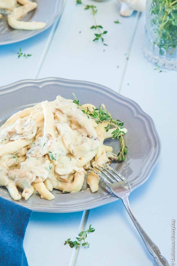 vegan alfredo sauce being served over pasta