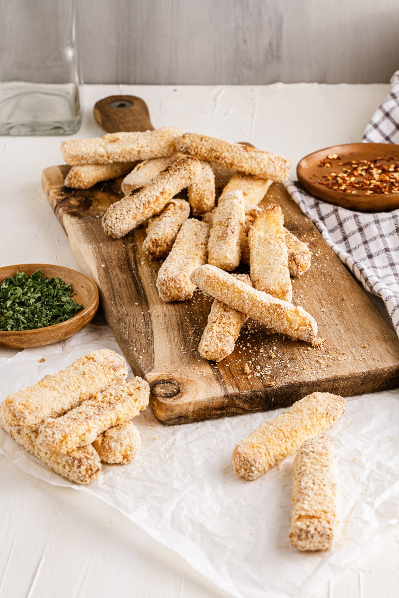 halloumi fries stacked on wooden serving board