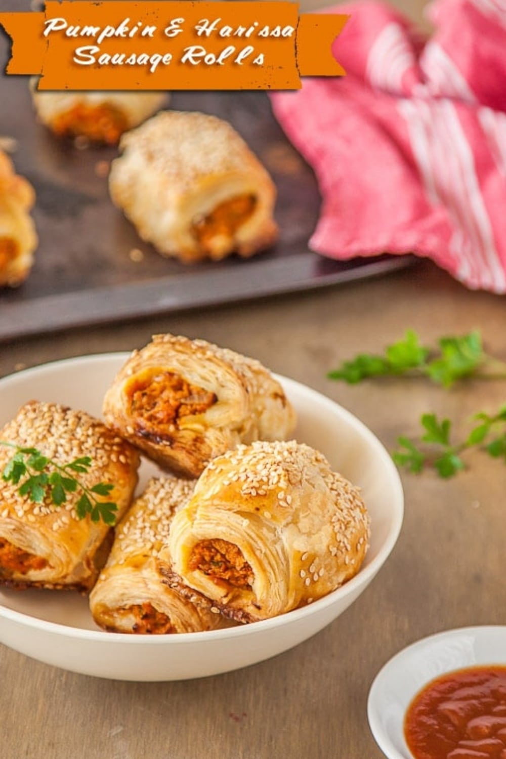 Pumpkin & Harissa vegetarian sausage rolls being served