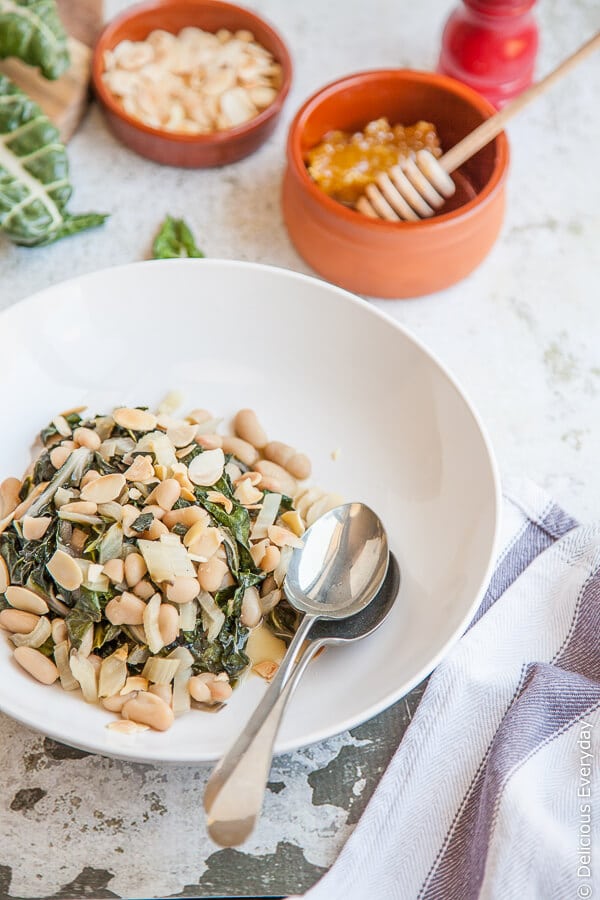 Quick, easy and delicious! This super side pairs slightly bitter chard with sweet honey, cannelloni beans and toasted almonds comes together in under 15 minutes. | Get this and more vegetarian recipes at DeliciousEveryday.com