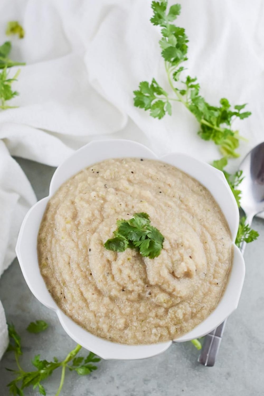 vegan cauliflower soup being served in a white bowl