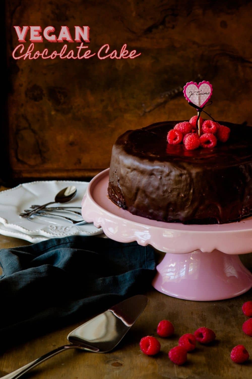 Vegan chocolate cake Pinterest graphic with glossy chocolate ganache and raspberries