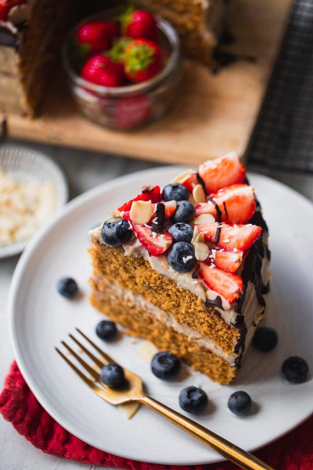 slice of gingerbread cake on a white plate with fruit