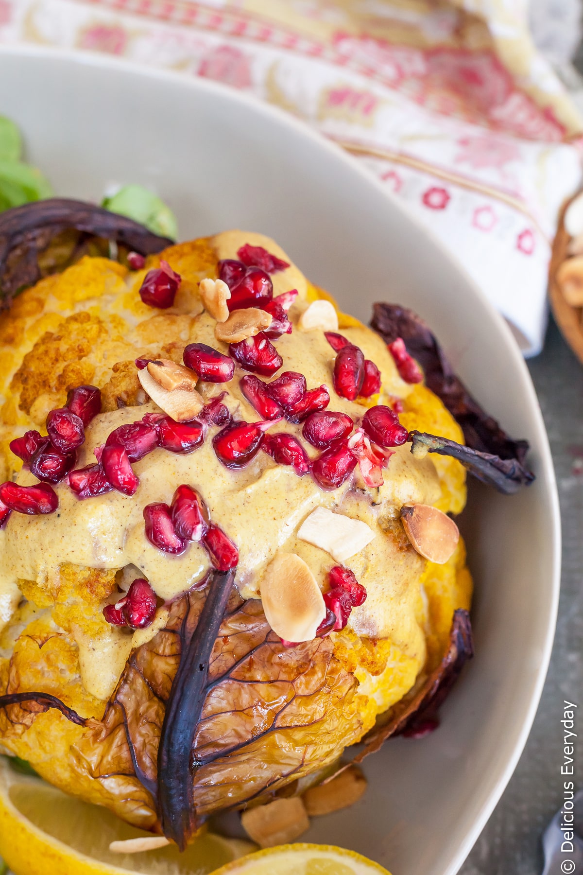 This Whole Roasted Cauliflower Head recipe is a wonderful way to enjoy cauliflower as baking it really amps up the flavour. Bathed in an nutty Tahini Sauce with gorgeously fragrant ras el hanout topped with pomegranate seeds and toasted almonds its a far cry from the cauliflower you pushed around your plate growing up!