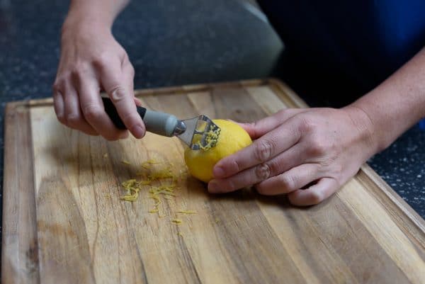 woman demonstrating how to zest a lemon