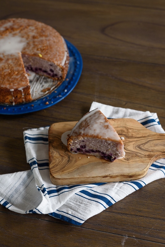 blueberry lemon yogurt cake being served on a wood table