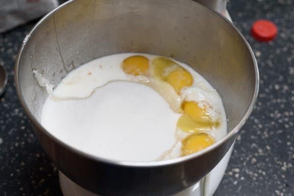 adding the wet ingredients for the lemon cake to the mixing bowl