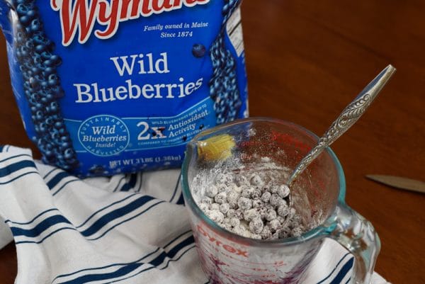 tossing frozen blueberries with flour