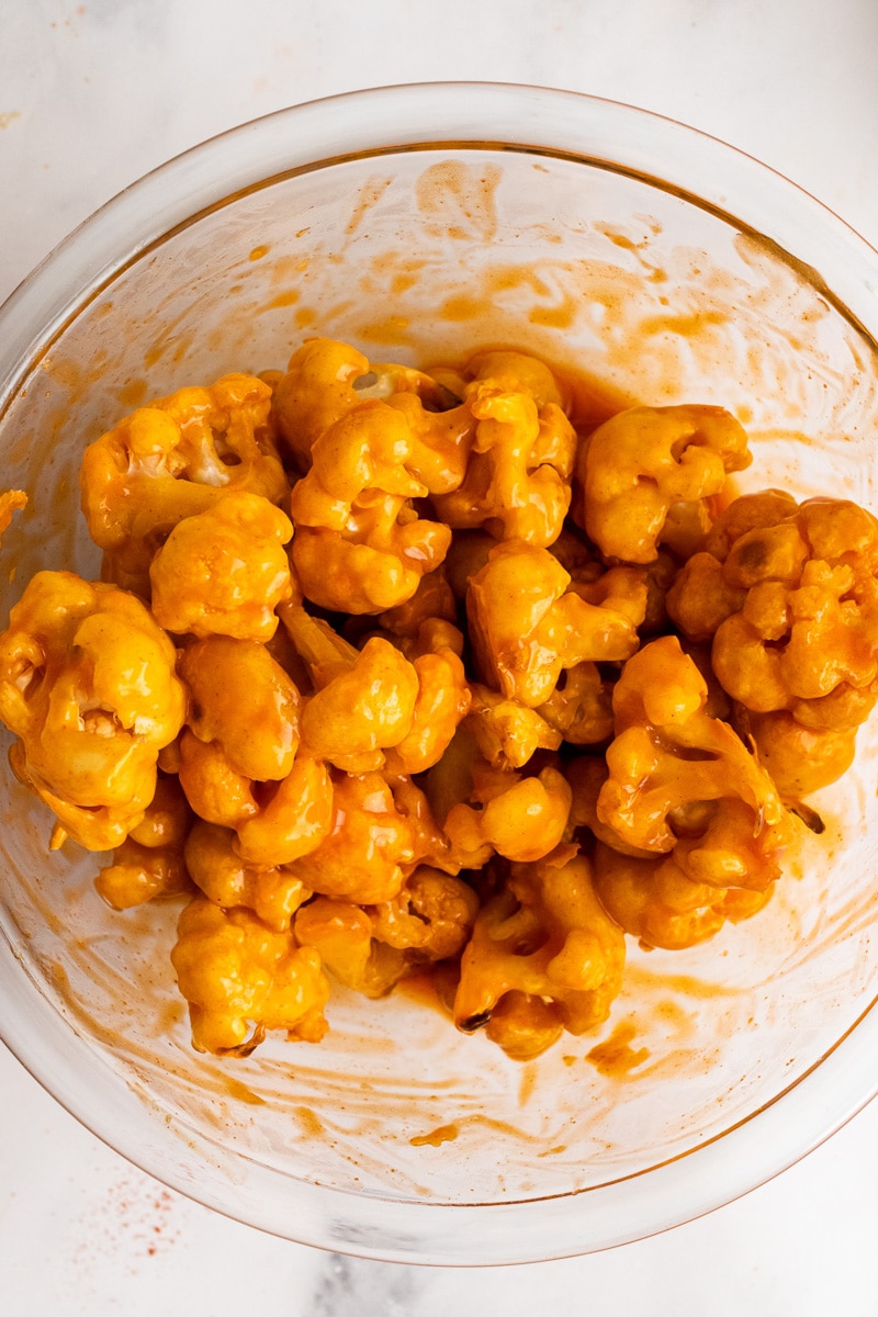 baked buffalo cauliflower in a bowl and covered in sauce