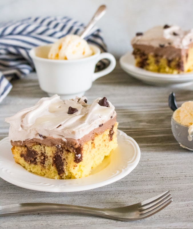 triple chocolate poke cake on a dish with ice cream