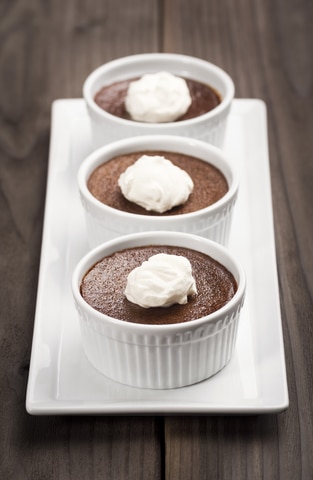 three ramekins of chocolate pots de creme being served