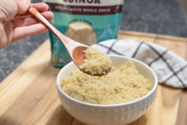 quinoa on a spoon over a white bowl