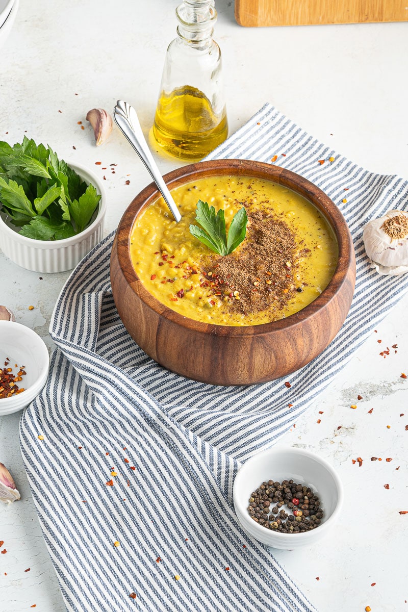 bowl of one-pot coconut lentil curry on striped dishtowel with small bowls of ingredients