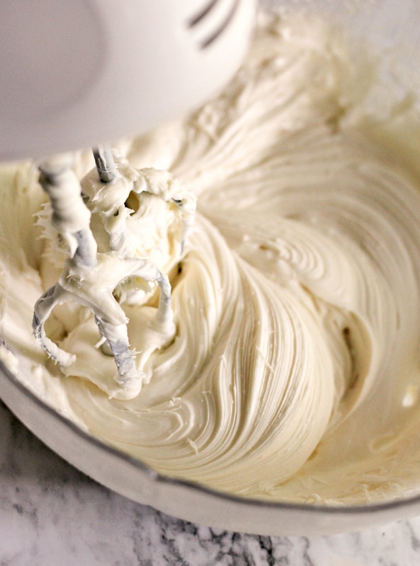 mixing the cream cheese frosting with a blender