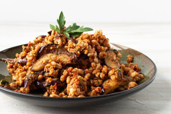 farro with eggplant and sun dried tomato pesto, topped with a sprig of parsley