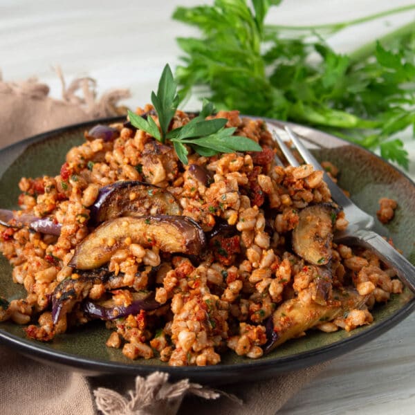 farro with sun dried tomato pesto, being served on a black plate