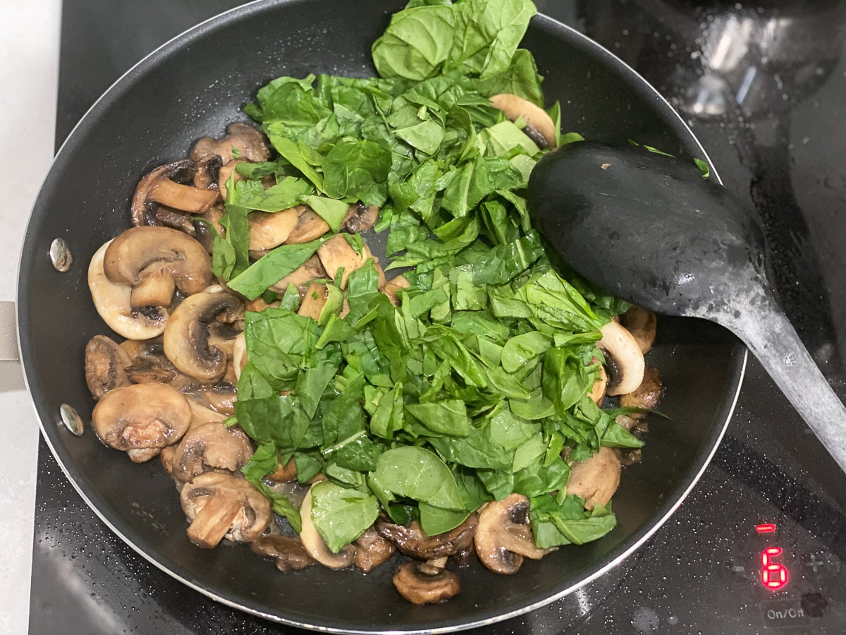 mushrooms and spinach in cooking pan