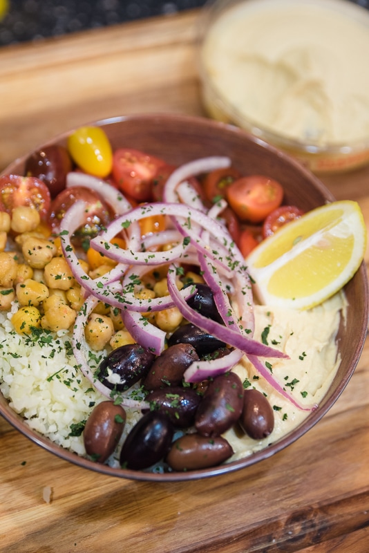 completed hummus bowl topped with veggies and chickpease