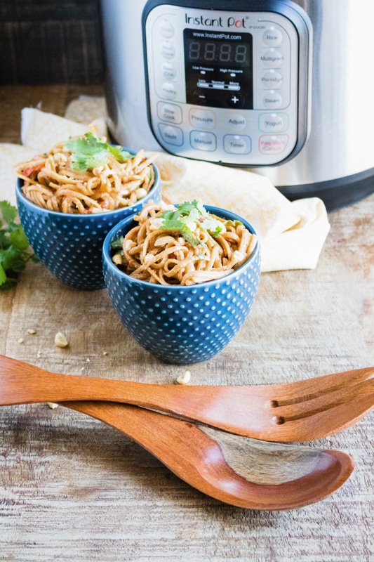 thai noodles made in the instant pot being served in blue dishes