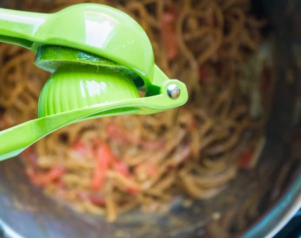 squeezing lime over thai peanut noodles