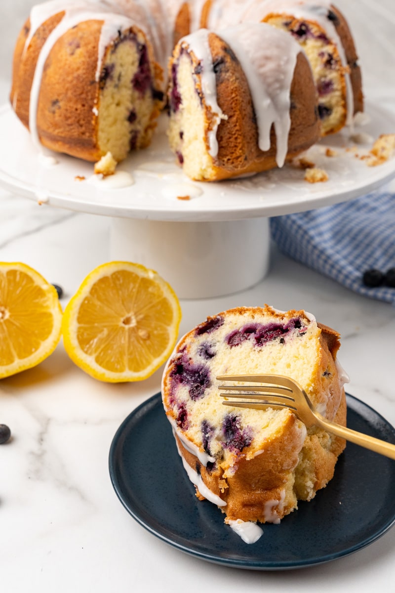 a slice of lemon blueberry bundt cake being eaten with a fork