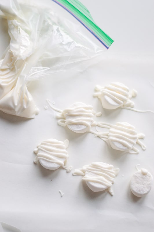 decorating marshmallows for halloween mummy cupcakes