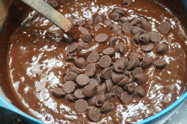 mixing chocolate chips into brownie batter