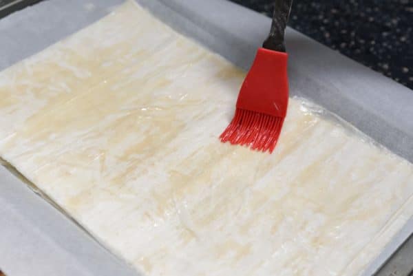 brushing butter on phyllo crust for mediterranean flatbread
