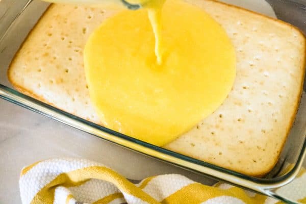 spreading pina colada filling on top of cake