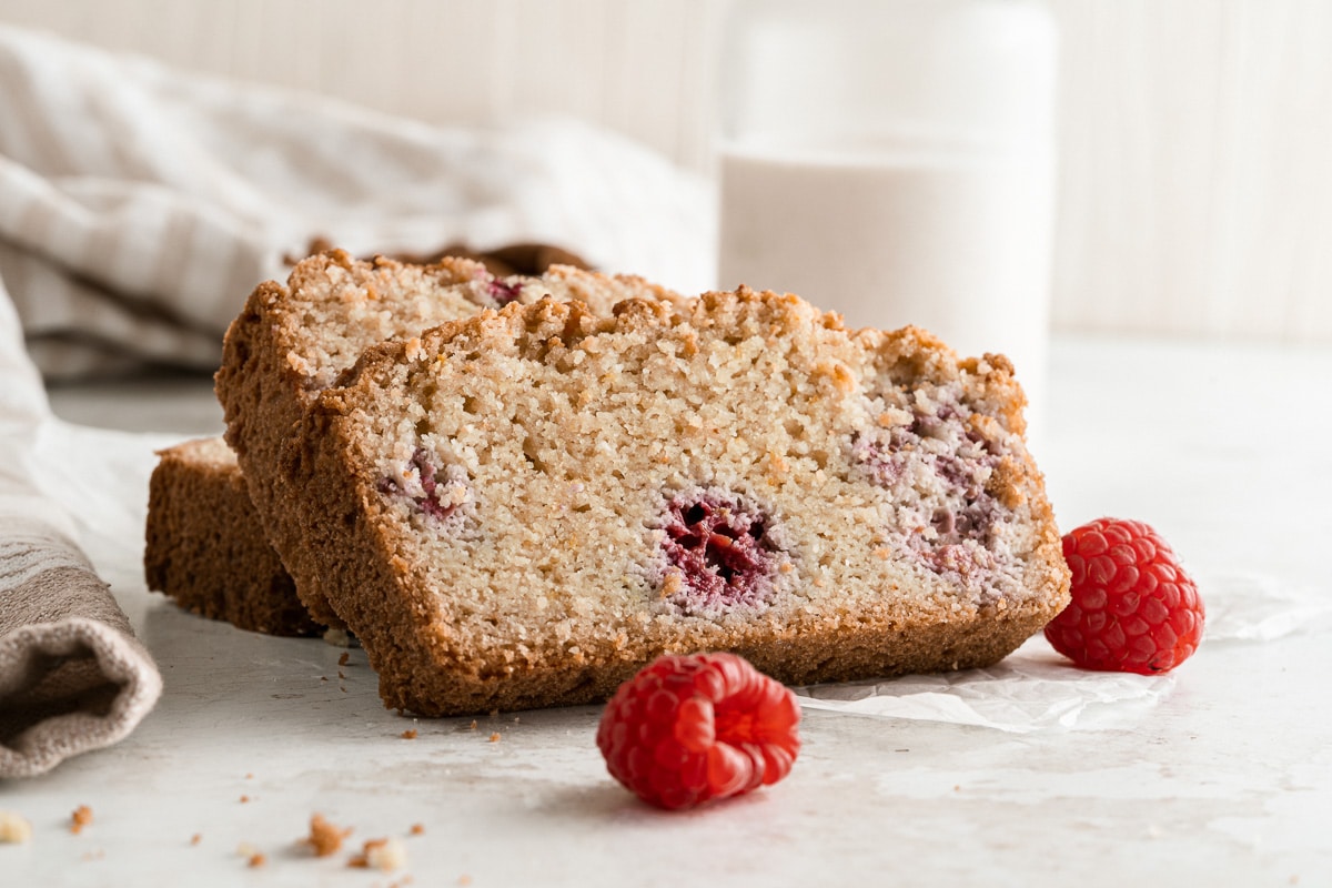 two slices of raspberry bread with a glass of milk in the background