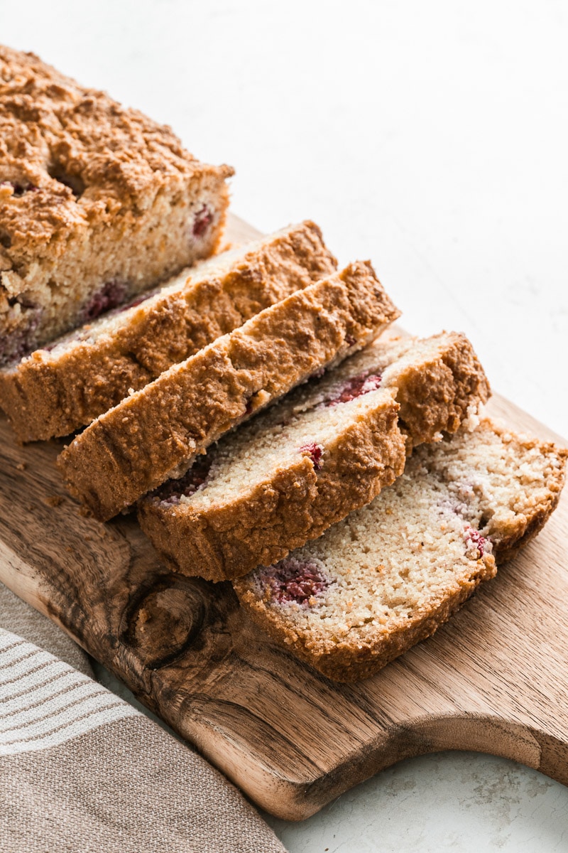 slices of raspberry bread on a wooden bread board