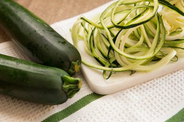 shredding zucchini on a cutting board