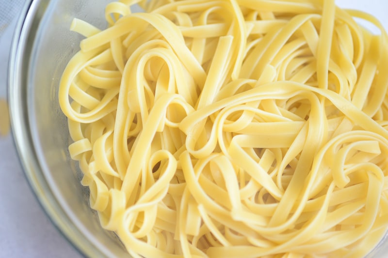 fettucine noodles in a bowl waiting for thai peanut sauce