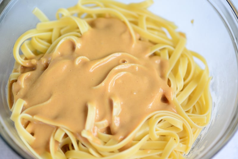 adding thai peanut sauce to the noodles