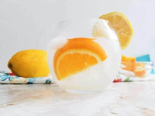 tom collins cocktail being served with a slice of orange
